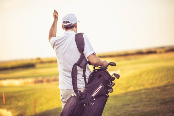 istock Senior golfer walking on golf court with bag. 1313423140