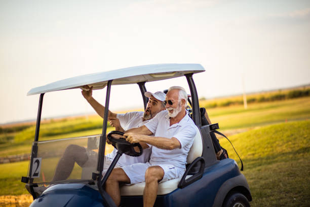 istock Two older friends are riding in a golf cart. 1313423213