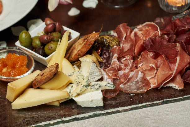 istock plate with thinly sliced ham, ham, blue cheese, parmesan and large olives 1313427328