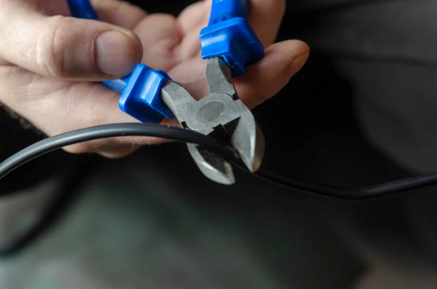 istock Defocus, selective focus, blur. A man is cutting a black electric wire with side cutters. 1313427514