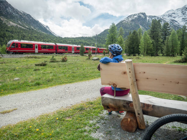 istock Mountain biker sits on bench and looks at mountain landscape 1313427777