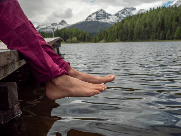 istock Feet dangling from lake pier 1313428537