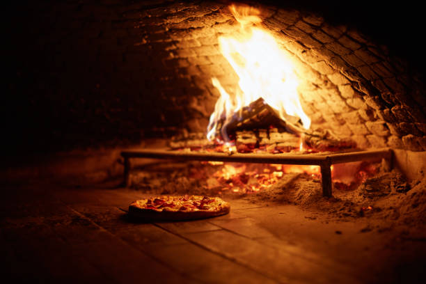 istock Delicious pizza baking in a wood fire oven 1313428581