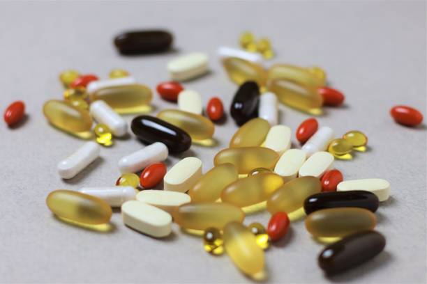 omega-3, vitamin d3, vitamin c, lecithin, lutein - vitamine auf leichtem hintergrund. gesundes ernährungs-, gesundheits- und medizinkonzept. nahaufnahme, selektiver fokus - lecithin capsule brown vitamin pill stock-fotos und bilder