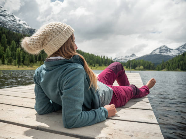istock Young woman relaxing on lake pier 1313428662