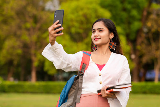 istock Young woman taking selfie on mobile phone at park 1313430786