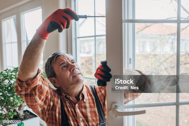 A Worker Installs Windows Stock Photo - Download Image Now - Window, Repairing, Residential Building