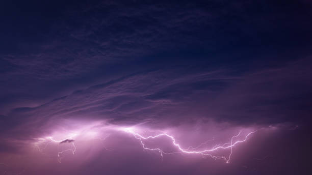 istock Bright Lightning On Purple Night Sky During Hunderstorm 1313437595