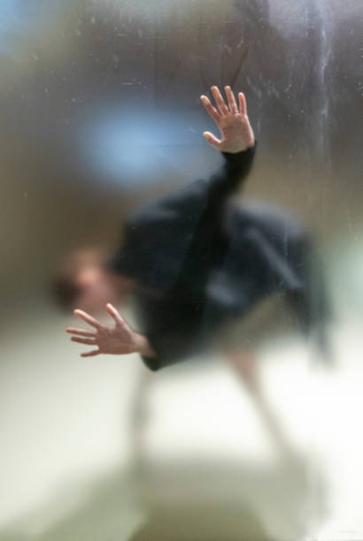 すりガラスの背後にある女性のジェスチャー恐怖 - trapped horror fog human hand ストックフォトと画像