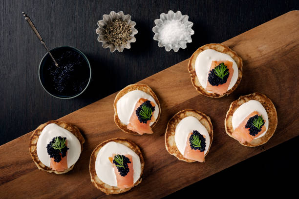 blinis com creme fraiche, salmão defumado e caviar toppeed com dill - appetizer caviar gourmet blini - fotografias e filmes do acervo