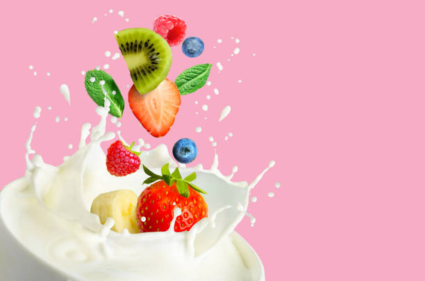 istock Fruit and bery mix falling into the bowl with milk and splashing on a pink background. 1313443744