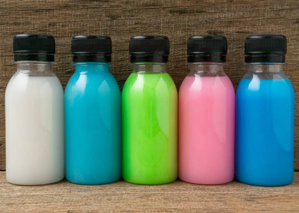 istock Colorful liquid in a bottles on wooden board background. 1313445469
