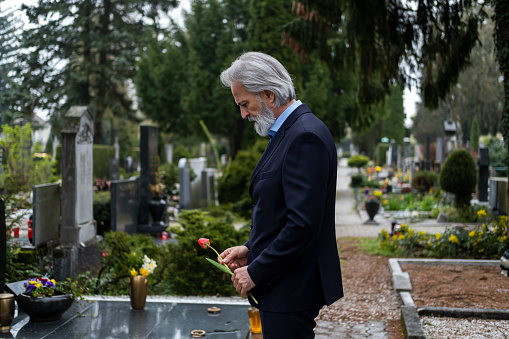 Sad senior man at cemetery