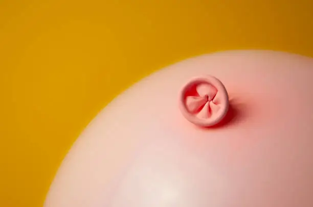 An image of a pink balloon on a yellow background. Metaphor prevention of hemorrhoids, anus hygiene, proctology, bowel health. High quality photo