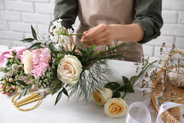 istock Florist making beautiful bouquet at white table, closeup 1313448121