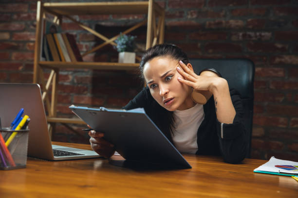 istock Young woman working in modern office using devices and gadgets. Making reports, analitycs, routine processing tasks 1313448214