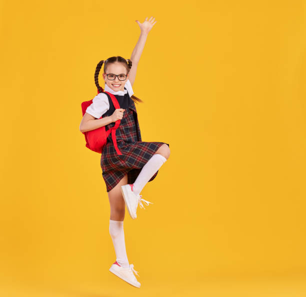 istock Excited schoolgirl jumping high in studio 1313449847