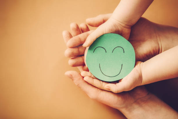 istock Paper smiling face in child and mother hands 1313451045