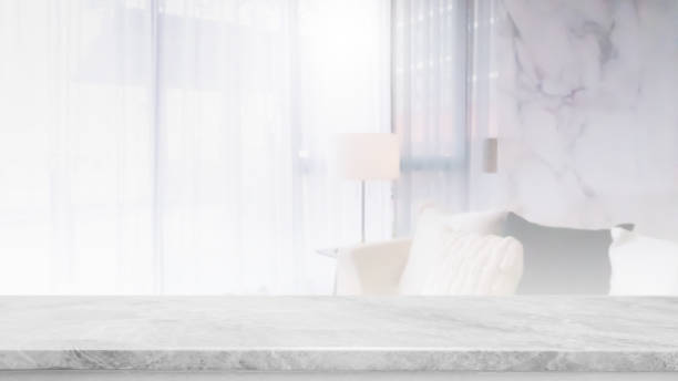 istock Empty white marble stone table top and blurred living room in home interior with curtain window background. - can used for display or montage your products. 1313453199