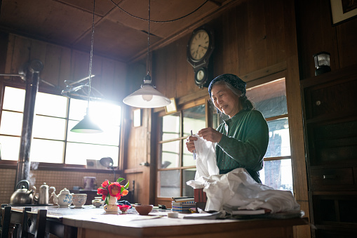 Senior woman sewing at home