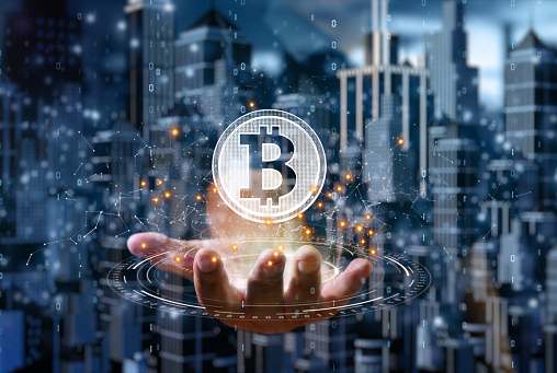 Businessman is holding a bitcoin as part of a business network, Cryptocurrency blockchain connection, Technology and financial investment background concept.