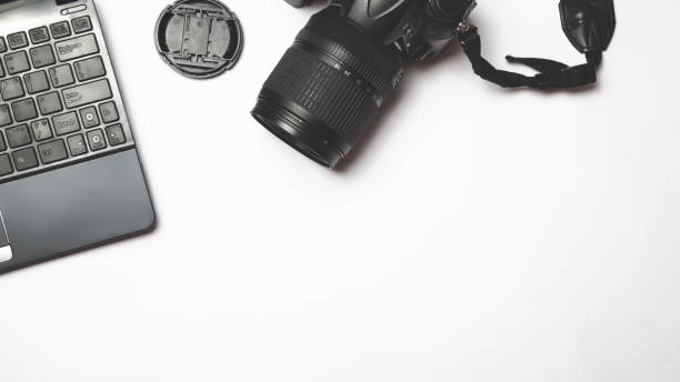 istock Photographer's workplace on a white background. Modern laptop, digital camera. Top view. Copy space. Equipment for the photographer. The concept of freelancing 1313455947