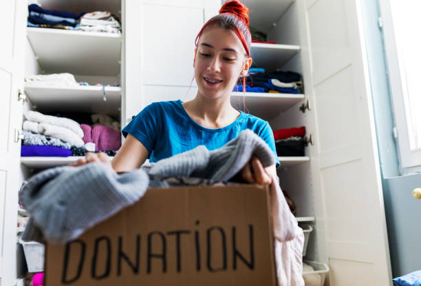 istock Young woman sorting clothes for donation 1313456480