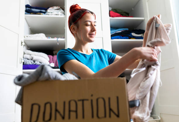 istock Young woman sorting clothes for donation 1313456518