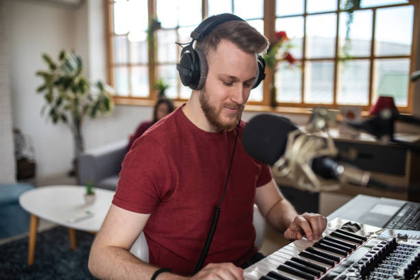 istock Young musician enjoying while playing synthesizer at his home music studio 1313458469