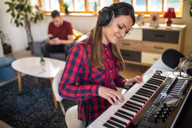 istock Young woman playing synthesizer at home 1313458604