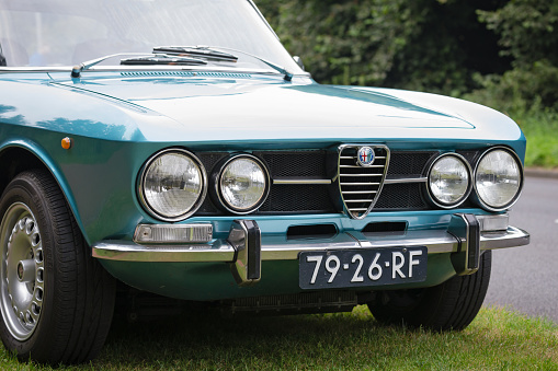 Wierden, Overijssel, Netherlands, september 17th 2016, close-up of the frontdide of a blue Dutch classic 1971 Alfa Romeo 1750 GT Veloce 2-doors coupe car parked on grass alongside the road - the car is also known as the \