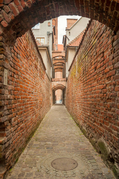 Poland - Elblag - The old city hidden red brick archs, walls and passageway with blurred silhuettes at far
