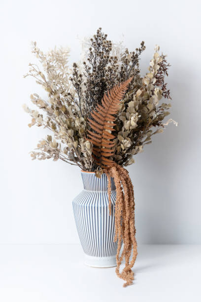 istock Stylish boho dried flower arrangement in a cream and blue stripe ceramic vase. 1313460300