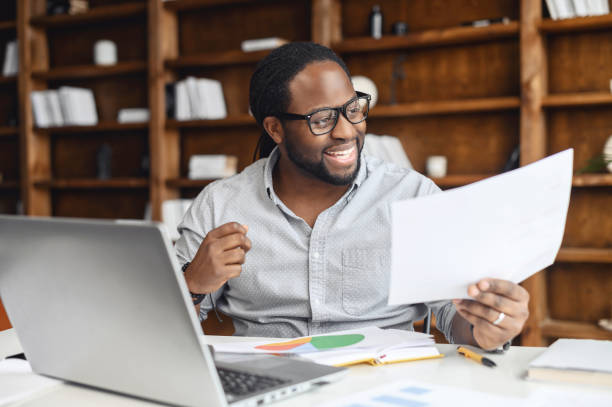 istock Young business man in glasses looking through workpaper 1313460701
