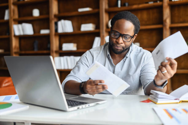Young business man in glasses looking through correspondence