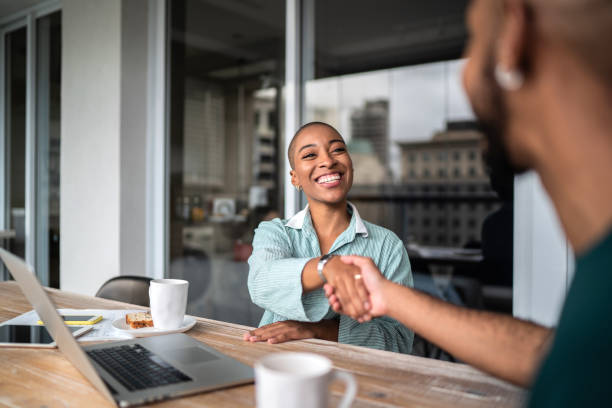 conseiller financier serrant la main du client - young men adult working gesturing photos et images de collection