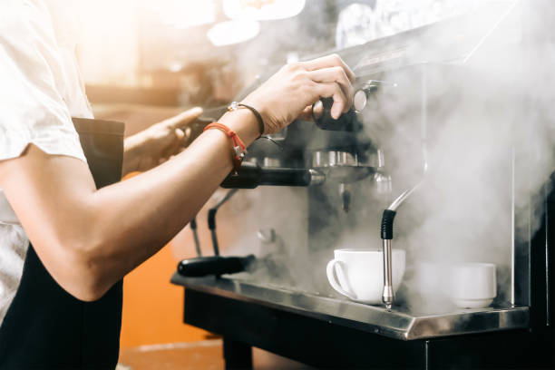 istock unrecognizable person manipulating a machine to make coffee and that makes steam. 1313463452