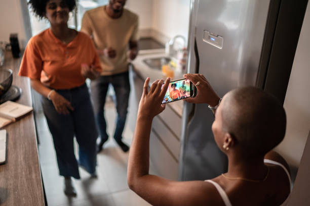 istock Friends dancing and filming it on mobile phone at home 1313464885