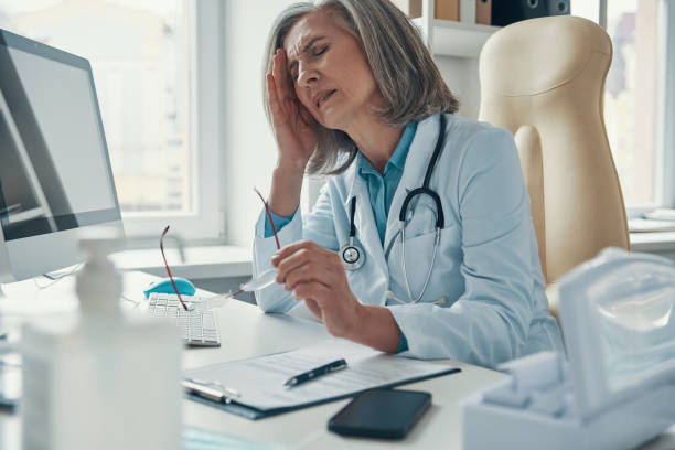 istock Overworked mature female doctor in white lab coat 1313464902