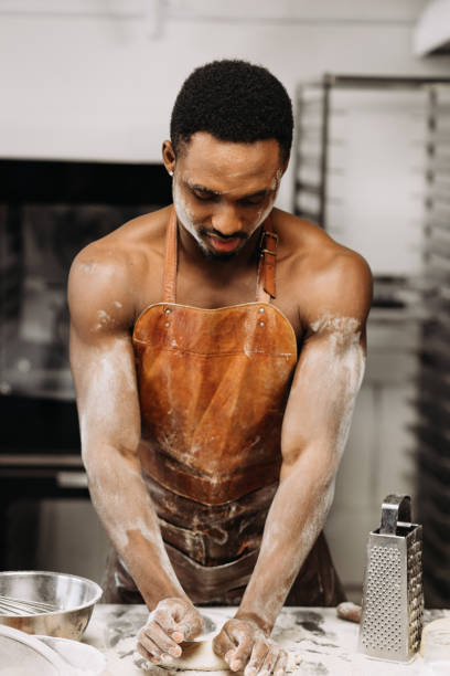 istock Young man kneads dough in the kitchen 1313465760