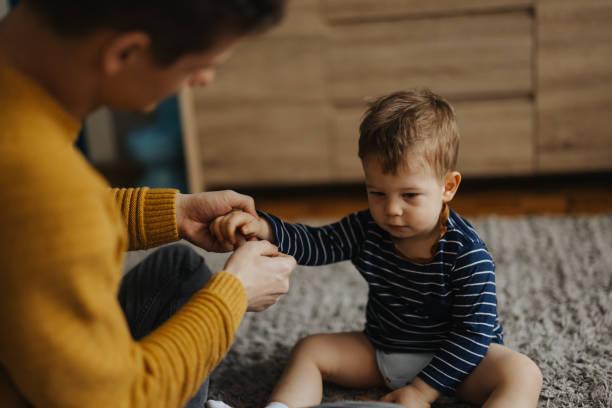 istock Young father dressing up his little son at home 1313468765
