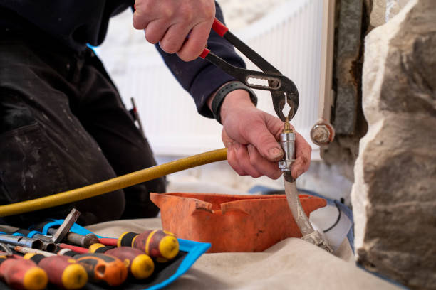 Hard at Work A close-up shot of an unrecognisable, Caucasian plumber adjusting a pipe to help fix the radiator in a clients home. heating engineer stock pictures, royalty-free photos & images