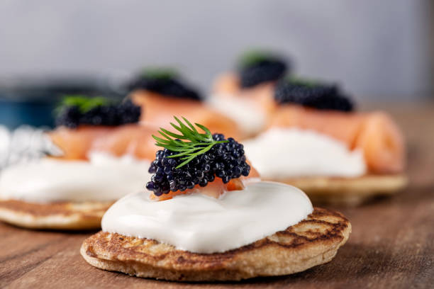 blinis caseros con creme fraiche, salmón ahumado y caviar - blini fotografías e imágenes de stock