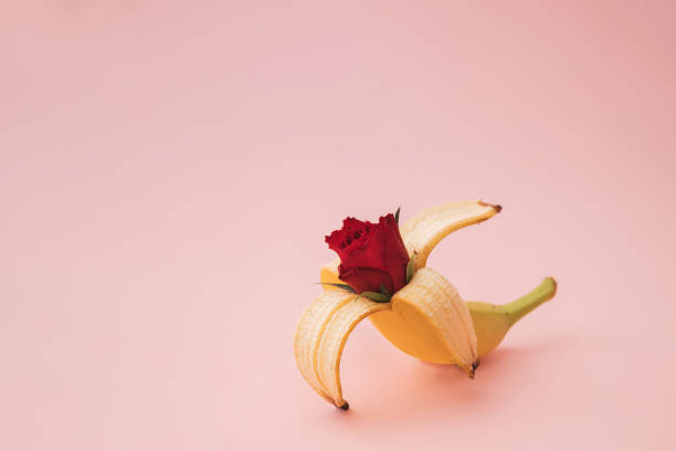 istock Banana red rose on pink background. Idea concept. 1313472278