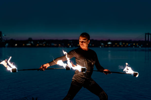 istock Fire artist posing with flaming torches 1313473153