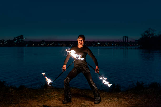 istock Fire artist posing with flaming torches and laughing 1313473179
