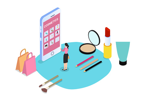 Young woman buying cosmetics online on the mobile phone while standing with shopping bags and beauty equipments