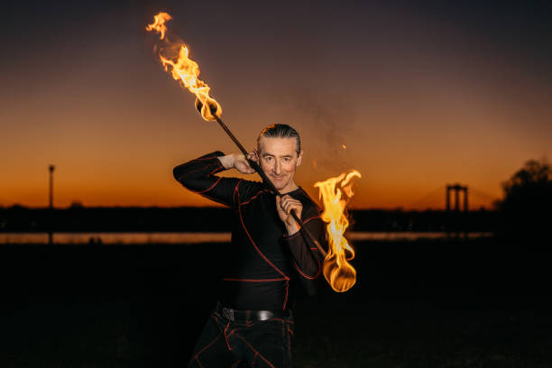 istock Fire artist posing with a flaming torch at night 1313474522