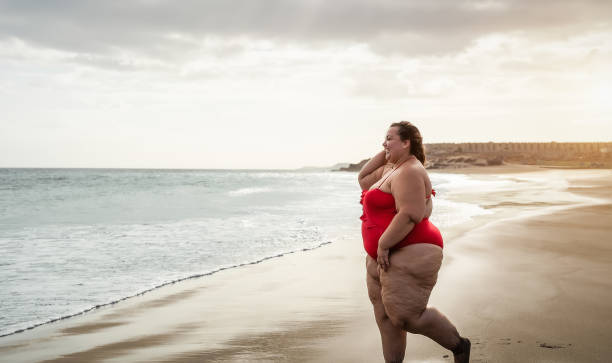 istock Happy plus size woman having fun walking on tropical beach during summer time - Curvy confident people lifestyle concept 1313475325