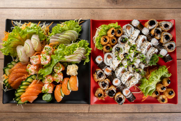 platos con sashimis, niguiris y sushi surtido - niguiri sushi fotografías e imágenes de stock